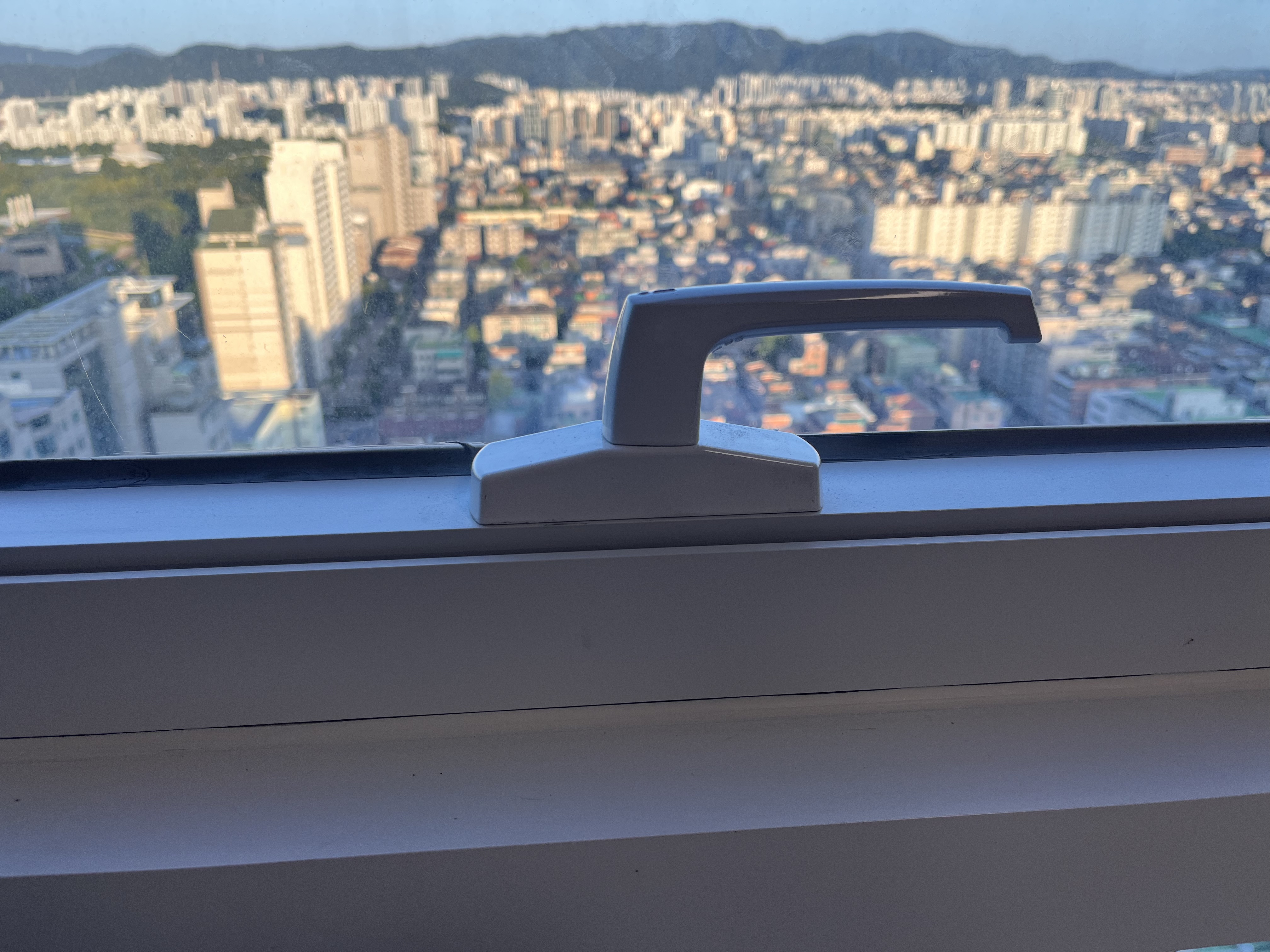 서울 송파구 잠실 성희파크빌 알루미늄 프로젝트창의 흰색 손잡이가 고장 나 창문이 잠긴 채 열리지 않는 상태다. 프로샷시가 손잡이를 분해해 내부 톱니바퀴 파손을 확인하고 동일한 제품으로 교체 수리했다.